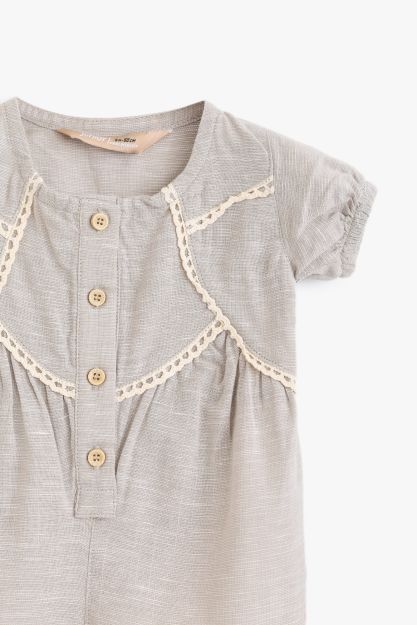 Textured cotton baby girl romper with lace trim bib detail and wooden button front 0-3 mth Front | Locafy