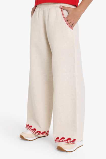 Girls wide-leg beige linen blend pants with red wave embroidery at hem and red stitched pocket detail 4 yrs Front | Locafy